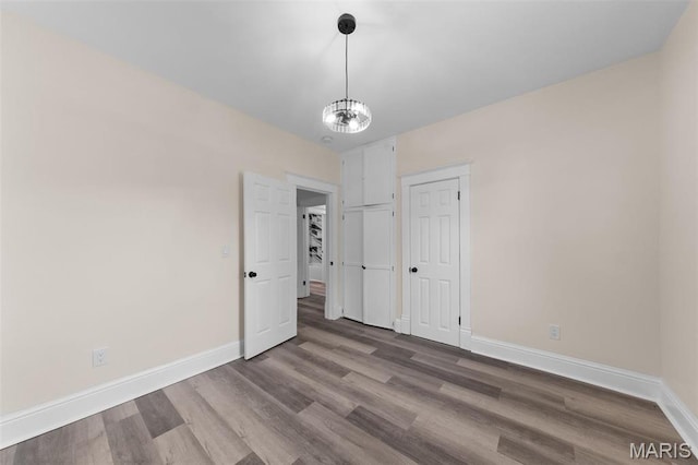 236 Georgia Ave, Saint Louis, MO 63135 - unfurnished bedroom featuring baseboards, wood finished floors, and a chandelier