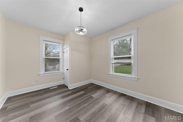 236 Georgia Ave, Saint Louis, MO 63135 - unfurnished dining area with wood finished floors, a chandelier, and baseboards