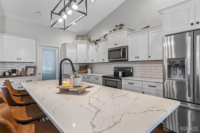 105 Shepherd Mountain Rd, Farmington, MO 63640 - kitchen with stainless steel appliances, lofted ceiling, white cabinetry, decorative backsplash, and a breakfast bar