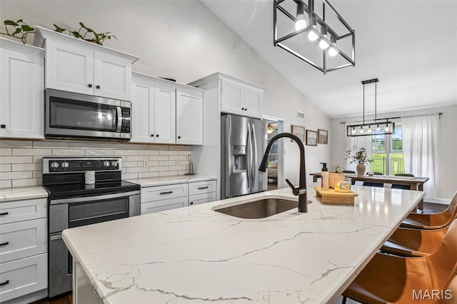 105 Shepherd Mountain Rd, Farmington, MO 63640 - kitchen featuring appliances with stainless steel finishes, a sink, decorative backsplash, an island with sink, and white cabinets