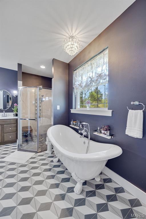 409 Pawnee Dr, Irondale, MO 63648 - full bath featuring a shower stall, a freestanding bath, vanity, tile patterned flooring, and baseboards