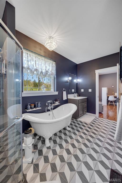 409 Pawnee Dr, Irondale, MO 63648 - bathroom featuring a shower stall, a freestanding bath, vanity, a chandelier, and tile patterned flooring