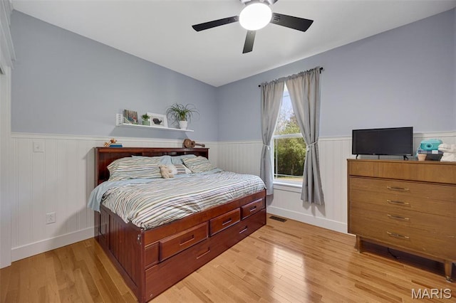 409 Pawnee Dr, Irondale, MO 63648 - bedroom featuring a wainscoted wall, light wood-style floors, a ceiling fan, and baseboards