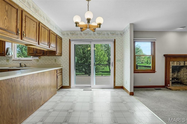 14 Sierra Dr, Glen Carbon, IL 62034 - kitchen featuring a chandelier, light countertops, baseboards, brown cabinetry, and light floors
