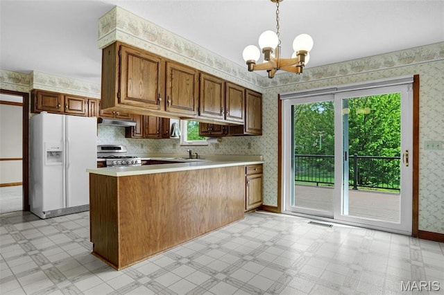 14 Sierra Dr, Glen Carbon, IL 62034 - kitchen featuring white fridge with ice dispenser, wallpapered walls, stainless steel range with gas cooktop, light flooring, and a chandelier