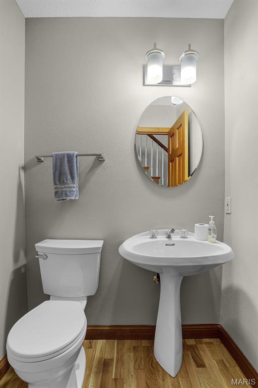 14 Sierra Dr, Glen Carbon, IL 62034 - half bathroom with baseboards, toilet, and wood finished floors