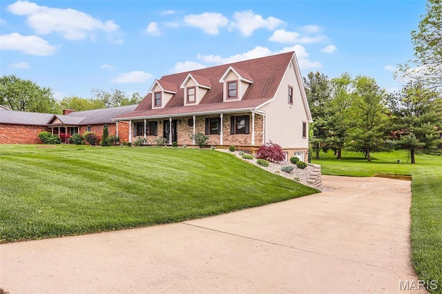 14 Sierra Dr, Glen Carbon, IL 62034 - new england style home with concrete driveway, covered porch, brick siding, and a front lawn