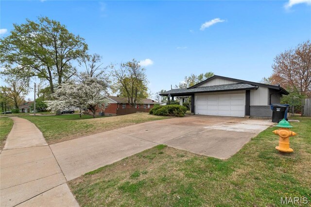 11735 Old Halls Ferry Rd, Florissant, MO 63033 - view of property exterior featuring a garage, a lawn, and driveway
