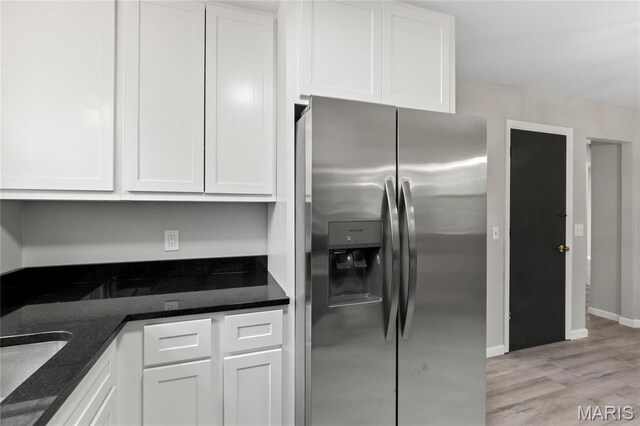 11735 Old Halls Ferry Rd, Florissant, MO 63033 - kitchen with stainless steel refrigerator with ice dispenser, white cabinetry, light wood-style flooring, dark stone countertops, and a sink