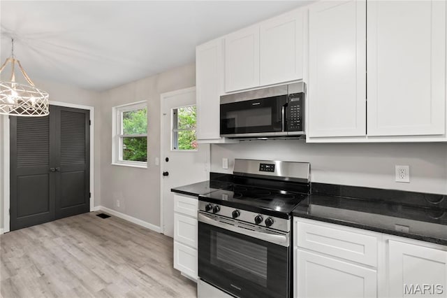 11735 Old Halls Ferry Rd, Florissant, MO 63033 - kitchen with stainless steel appliances, white cabinets, light wood-style flooring, and baseboards