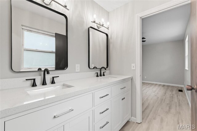 11735 Old Halls Ferry Rd, Florissant, MO 63033 - bathroom featuring double vanity, wood finished floors, and baseboards