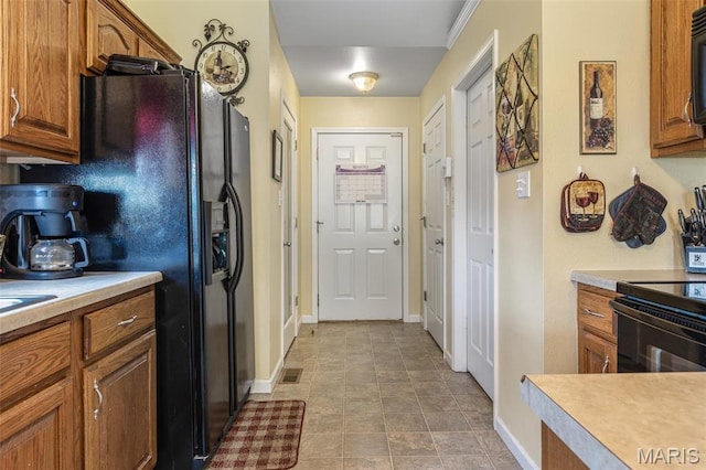 601 John David Dr, Farmington, MO 63640 - kitchen featuring black appliances, light countertops, brown cabinetry, and baseboards