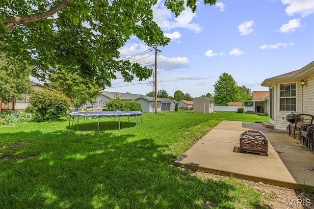 601 John David Dr, Farmington, MO 63640 - view of grassy yard with a fire pit, a trampoline, and a patio