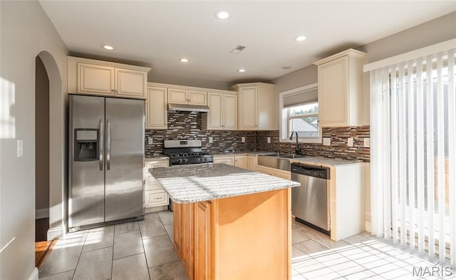 11175 Lexington Ln, Rolla, MO 65401 - kitchen featuring appliances with stainless steel finishes, under cabinet range hood, a center island, light stone counters, and a sink