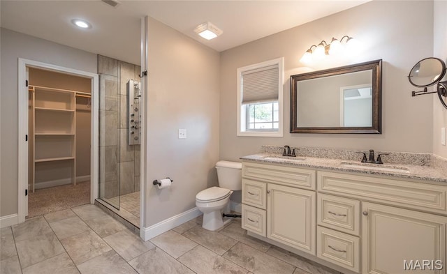 11175 Lexington Ln, Rolla, MO 65401 - bathroom featuring double vanity, toilet, a stall shower, baseboards, and a spacious closet