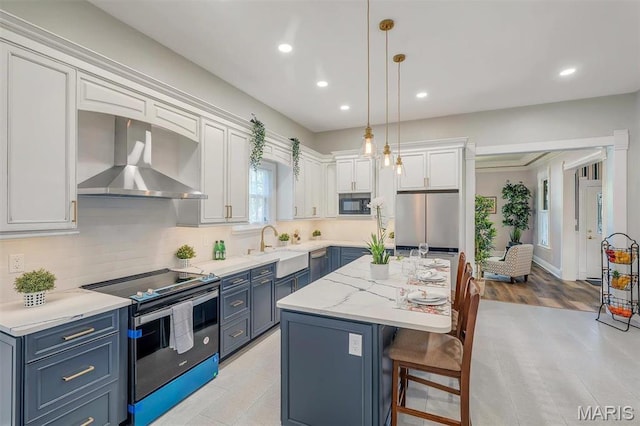 100 Lewis St, Troy, MO 63379 - kitchen with electric range oven, wall chimney range hood, freestanding refrigerator, a sink, and blue cabinets