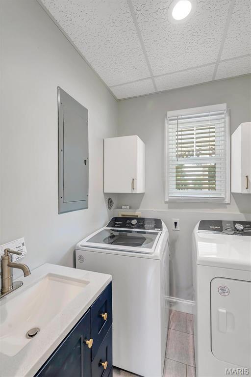 100 Lewis St, Troy, MO 63379 - laundry area with electric panel, cabinet space, washer and clothes dryer, light tile patterned flooring, and baseboards