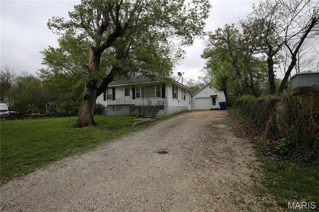 view of front of house with an outdoor structure, gravel driveway, a garage, a porch, and a front yard