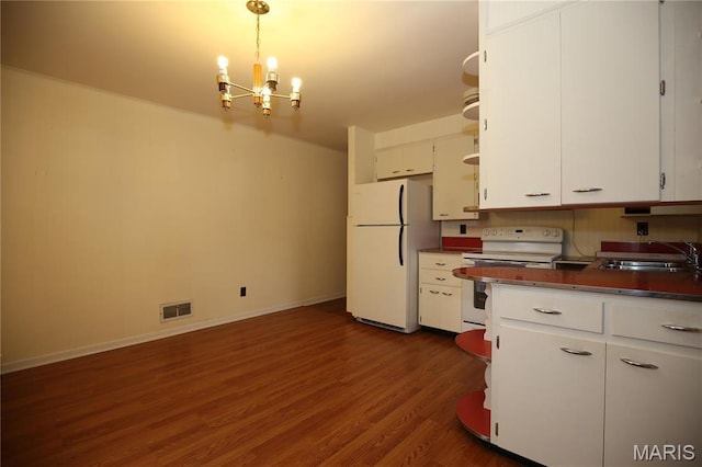 kitchen with white appliances, a sink, a chandelier, white cabinetry, and dark wood finished floors