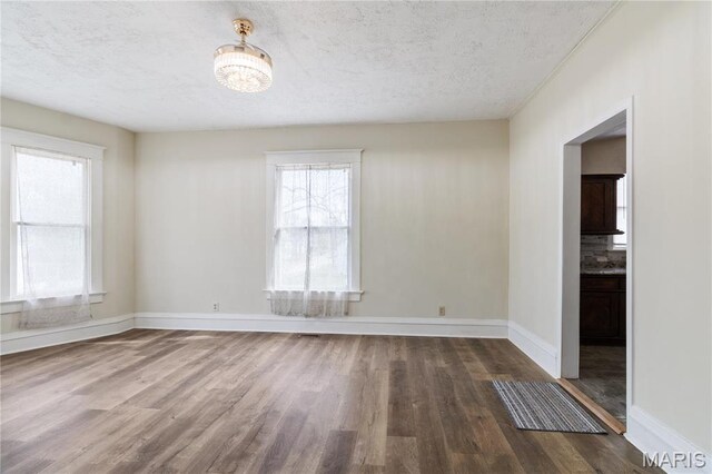 203 S B St, Bonne Terre, MO 63628 - empty room featuring wood finished floors, baseboards, and a textured ceiling