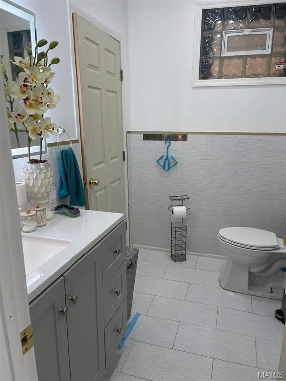 4007 Delor St, Saint Louis, MO 63116 - bathroom with tile walls, vanity, toilet, and wainscoting