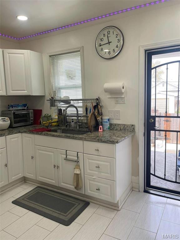 4007 Delor St, Saint Louis, MO 63116 - kitchen featuring a sink, white cabinetry, and dark stone countertops
