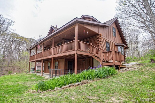 234 SE 350th St, Carrollton, IL 62016 - back of property with ceiling fan, a wooden deck, a lawn, board and batten siding, and log exterior