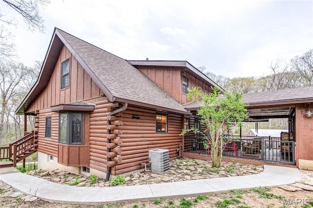 234 SE 350th St, Carrollton, IL 62016 - view of side of home with central AC unit, a shingled roof, log exterior, and board and batten siding