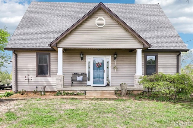 bungalow featuring covered porch, a front lawn, and a shingled roof