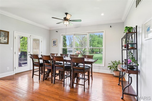 dining room with a ceiling fan, baseboards, hardwood / wood-style flooring, crown molding, and recessed lighting