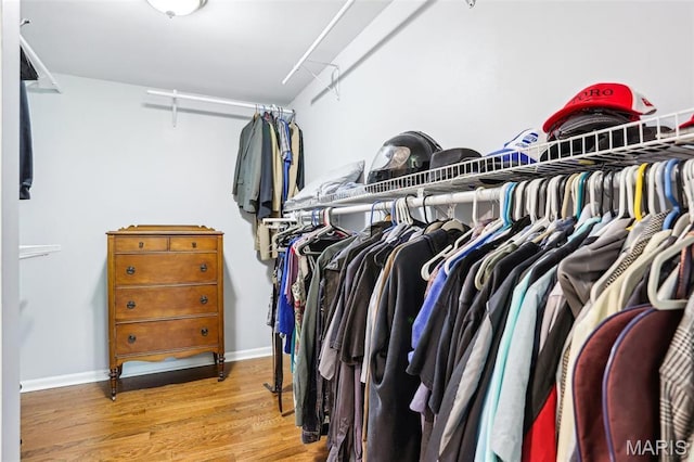 walk in closet with wood finished floors