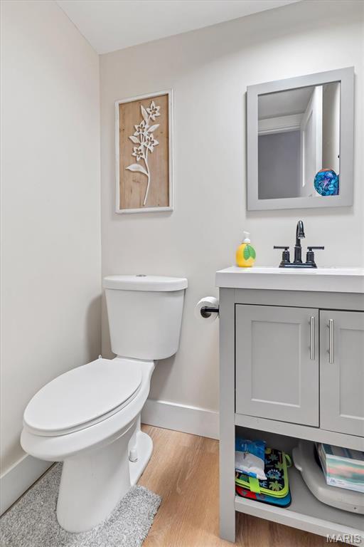 1 Picardy Dr, Lake St Louis, MO 63367 - bathroom featuring baseboards, toilet, vanity, and wood finished floors