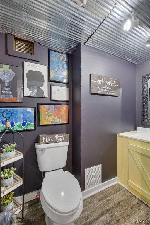 305 N Main St, Saint Genevieve, MO 63670 - bathroom featuring wood finished floors, toilet, and baseboards