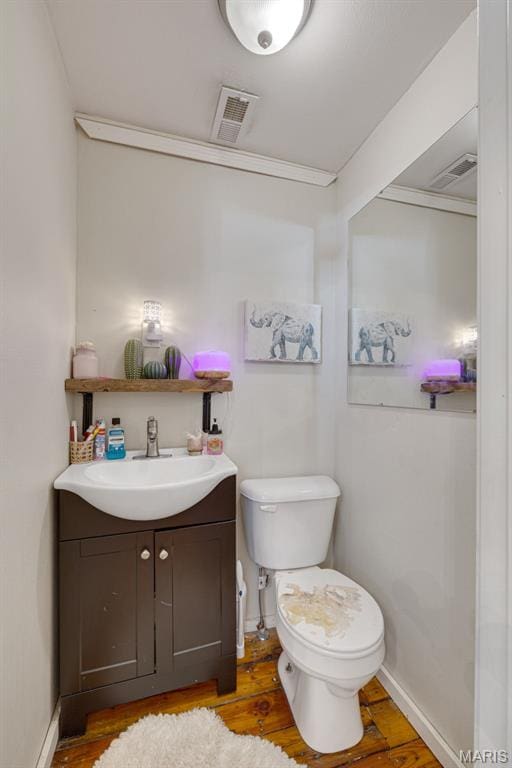 305 N Main St, Saint Genevieve, MO 63670 - bathroom featuring vanity, toilet, wood finished floors, and baseboards