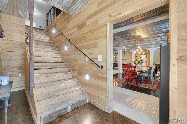 305 N Main St, Saint Genevieve, MO 63670 - stairway featuring wooden walls, wood finished floors, and a chandelier