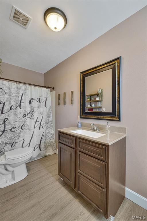 305 N Main St, Saint Genevieve, MO 63670 - bathroom featuring wood finished floors, toilet, vanity, and baseboards