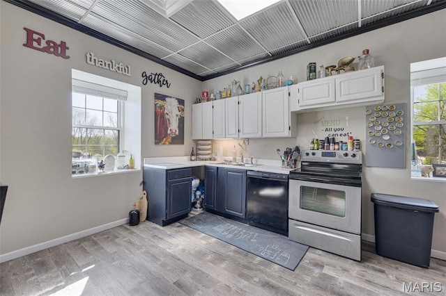 305 N Main St, Saint Genevieve, MO 63670 - kitchen with electric stove, dishwasher, light countertops, blue cabinetry, and white cabinets