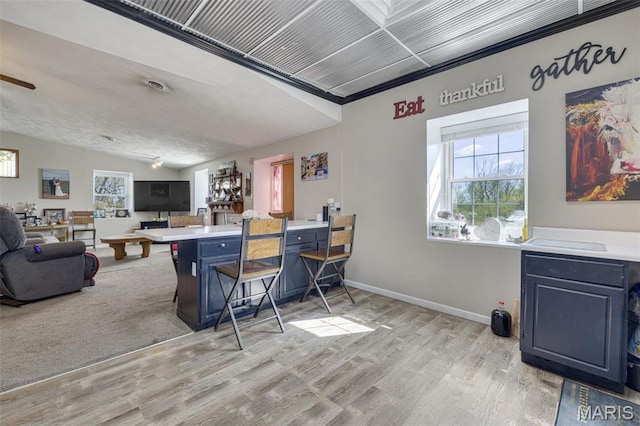 305 N Main St, Saint Genevieve, MO 63670 - kitchen with light wood-style floors, open floor plan, blue cabinets, light countertops, and a breakfast bar area