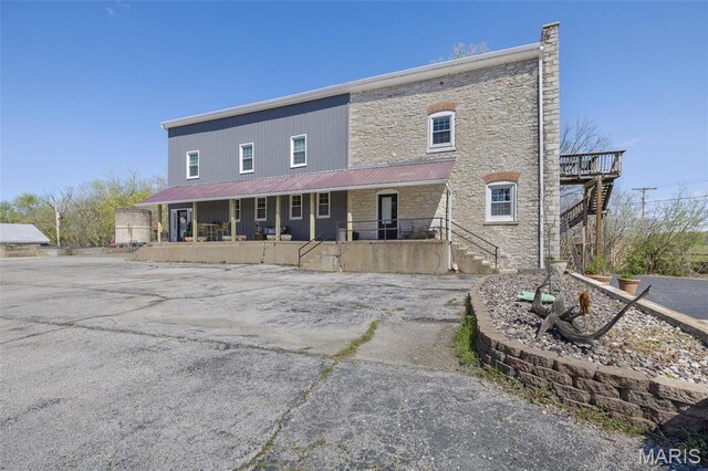 305 N Main St, Saint Genevieve, MO 63670 - view of front facade with covered porch, stone siding, stairs, and metal roof