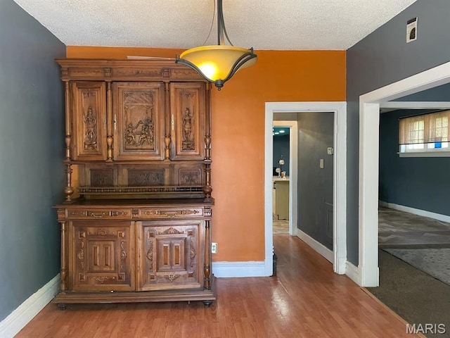 4972 Thekla Ave, Saint Louis, MO 63115 - corridor featuring baseboards, wood finished floors, and a textured ceiling