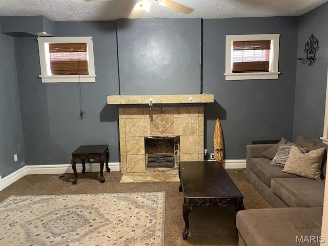 4972 Thekla Ave, Saint Louis, MO 63115 - living room featuring carpet, a textured ceiling, a fireplace, baseboards, and a ceiling fan