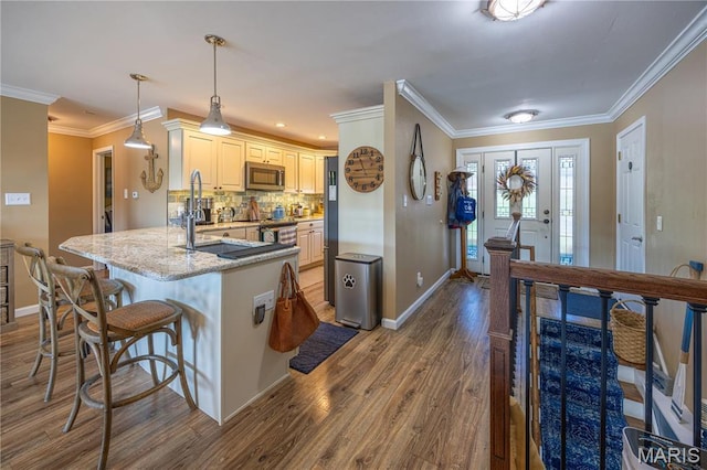 1757 Rue Marseilles, Bonne Terre, MO 63628 - kitchen with appliances with stainless steel finishes, dark wood-style flooring, baseboards, a kitchen bar, and light stone countertops