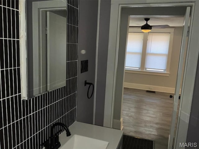 2538 Jerden Ave, Granite City, IL 62040 - full bathroom featuring baseboards, a ceiling fan, wood finished floors, tiled shower, and a sink