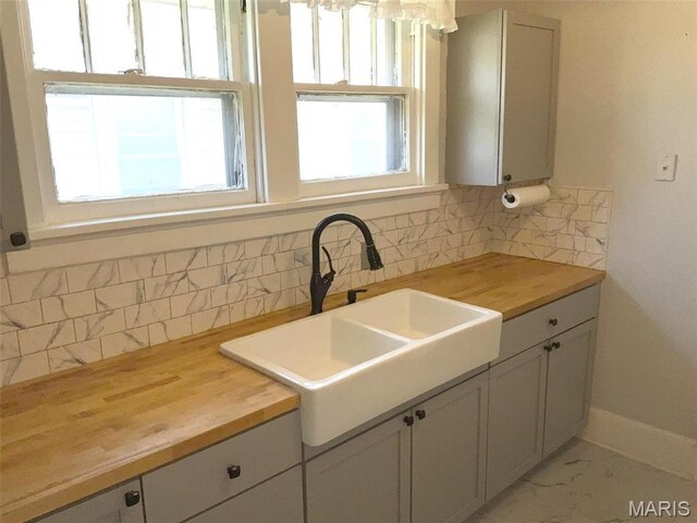 2538 Jerden Ave, Granite City, IL 62040 - kitchen with butcher block counters, a sink, decorative backsplash, and white cabinets