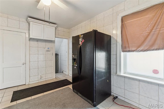 3125 Miami St, Saint Louis, MO 63118 - kitchen with black fridge with ice dispenser, tile walls, light tile patterned flooring, ceiling fan, and white cabinets