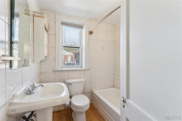 3125 Miami St, Saint Louis, MO 63118 - bathroom with wood finished floors, toilet, tile walls, and tub / shower combination