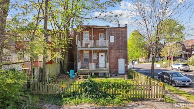 3125 Miami St, Saint Louis, MO 63118 - view of property featuring brick siding, a fenced front yard, and a balcony