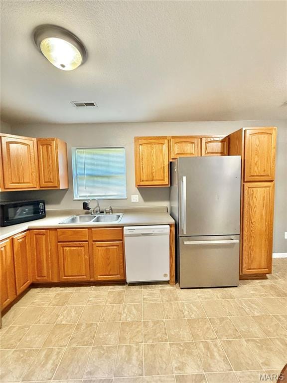 113 N Long St, Bonne Terre, MO 63628 - kitchen with dishwasher, freestanding refrigerator, black microwave, a sink, and light countertops