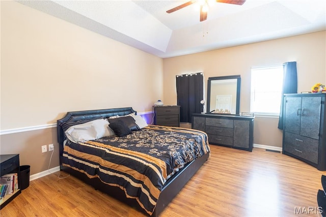 16910 Lawrence Dr, Saint Robert, MO 65584 - bedroom featuring wood finished floors, a tray ceiling, and a ceiling fan