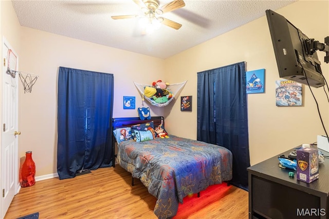 16910 Lawrence Dr, Saint Robert, MO 65584 - bedroom with wood finished floors, a ceiling fan, and a textured ceiling